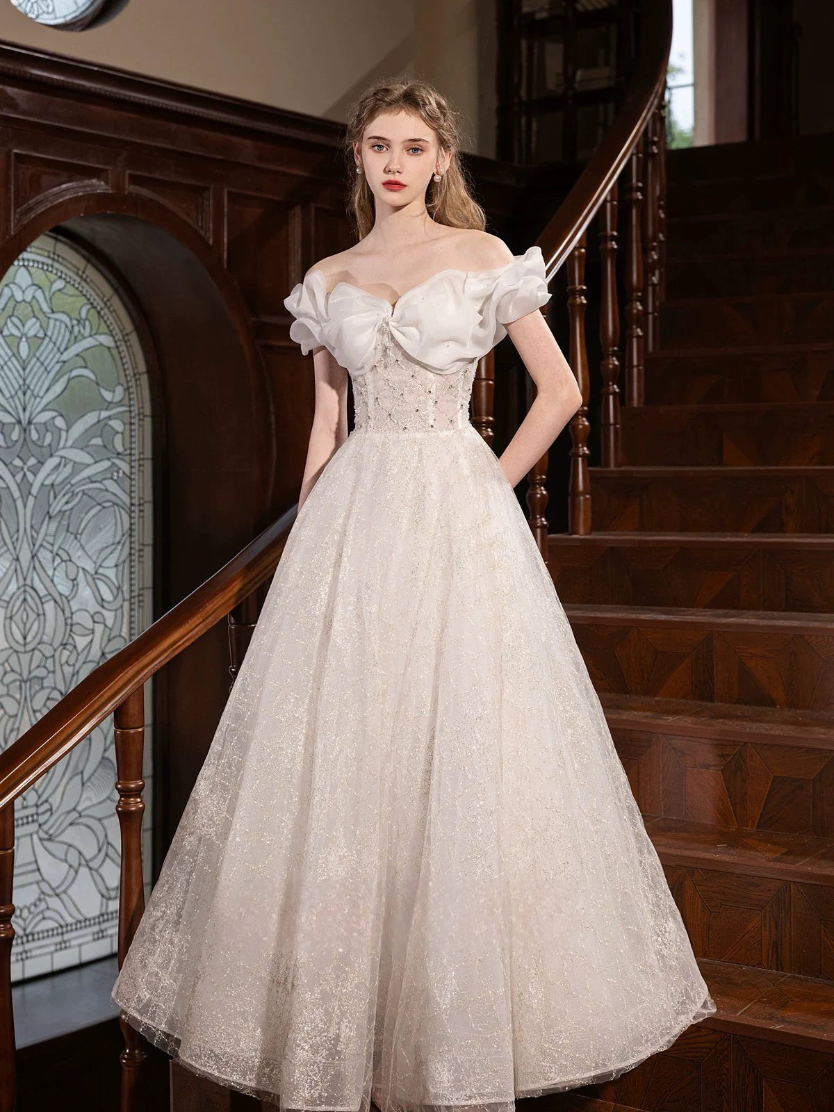 Elegant white A-line off-shoulder long prom dress on a model, front view.