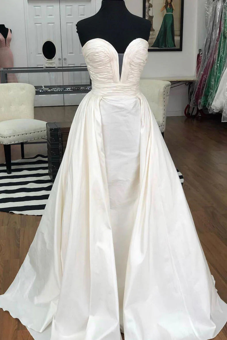 Woman wearing an elegant white off-shoulder long satin prom dress.