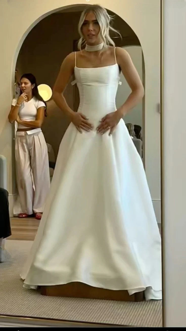 Back view of an A-line off-shoulder white satin wedding dress.