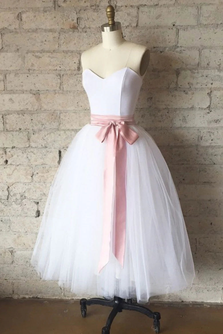 Model wearing an elegant off-shoulder white tulle tea-length prom dress.