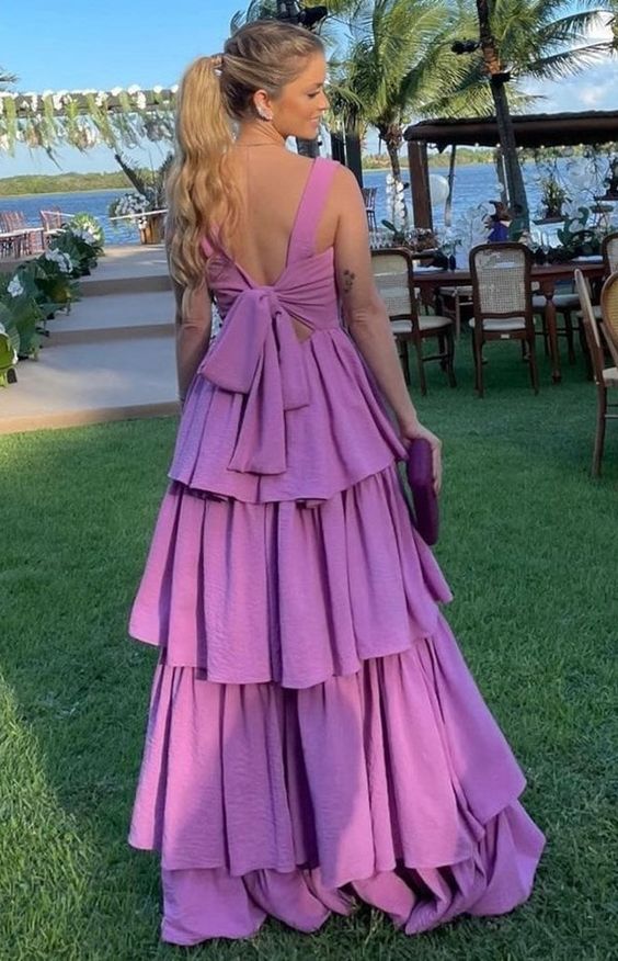 Back view of a woman in a flowing purple off-the-shoulder prom dress.