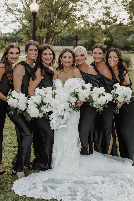Model wearing an elegant black satin one-shoulder pleated long bridesmaid dress with a high slit.