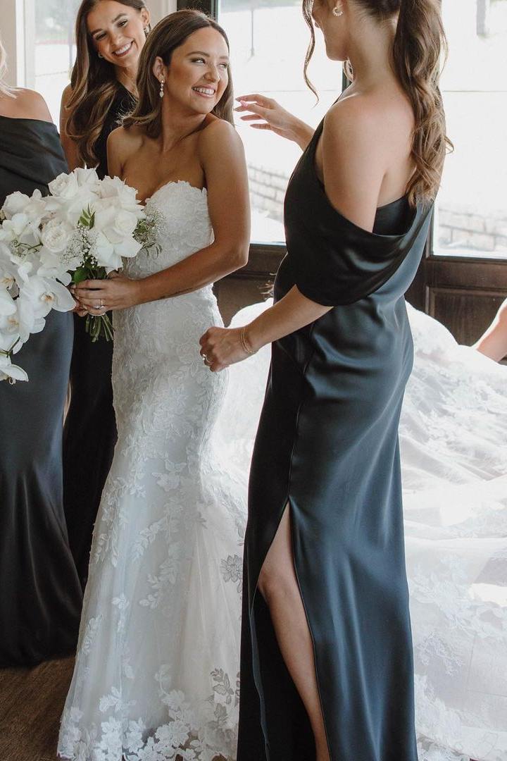 Back view of a model in the black satin one-shoulder pleated long bridesmaid dress.