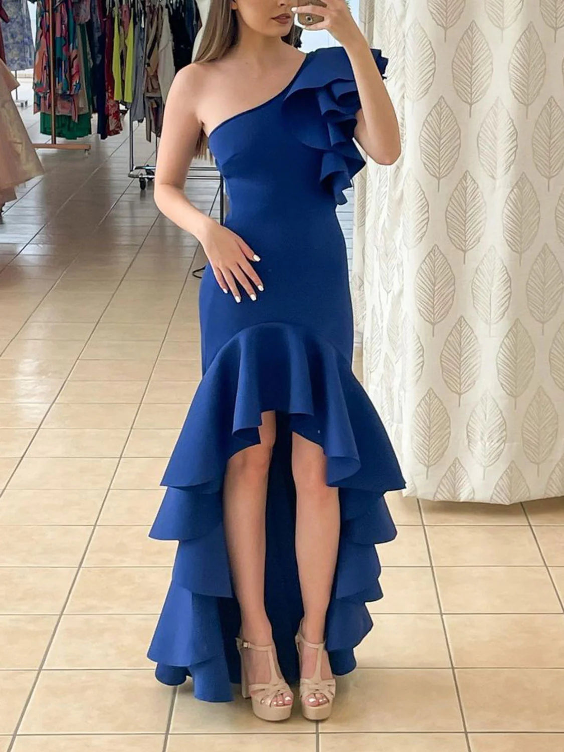 Back and side view of a woman wearing a royal blue satin one-shoulder cocktail dress.