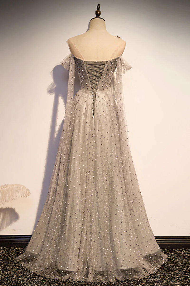 Side view of a model in a flowing gray one-shoulder long tulle formal dress.