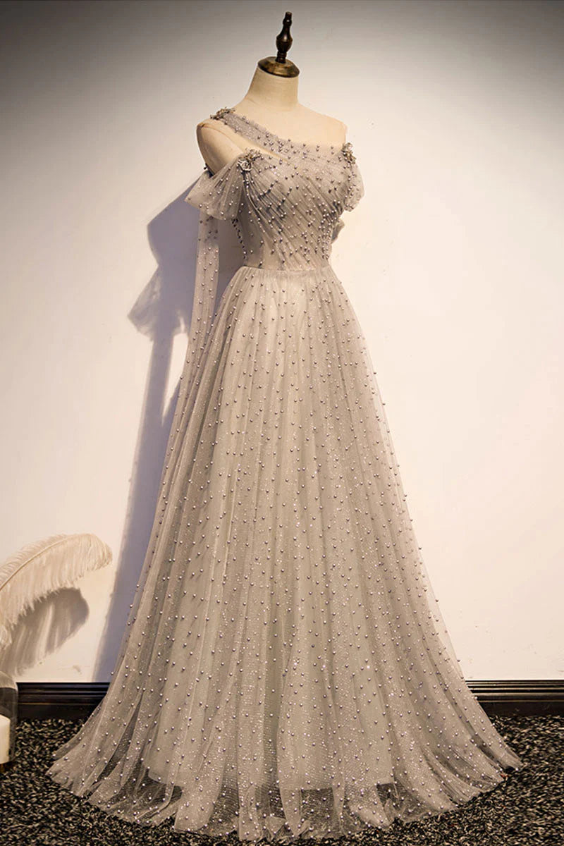 Back view of a model showcasing the elegant drape of a gray one-shoulder tulle gown.