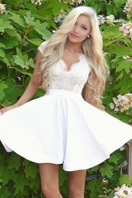 Woman in white mini dress with lace cap sleeves and open back.