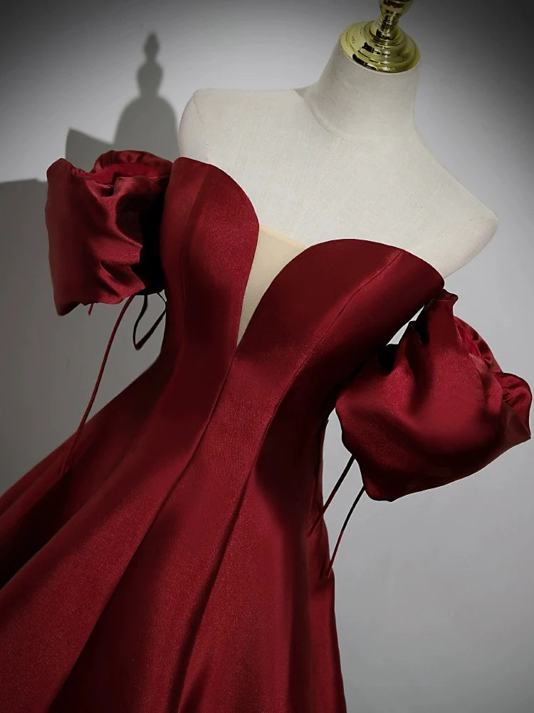 Side profile of the burgundy A-line formal gown, highlighting the satin fabric and puff sleeves.