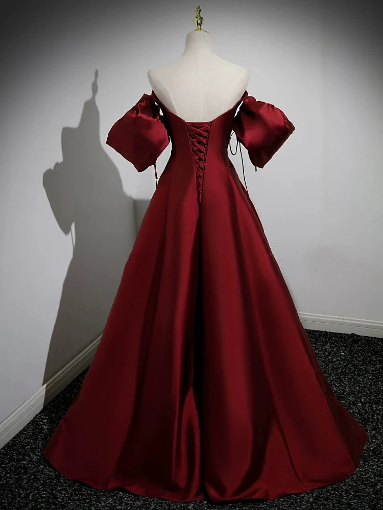Back view of the long burgundy satin dress, showcasing its elegant drape and design.