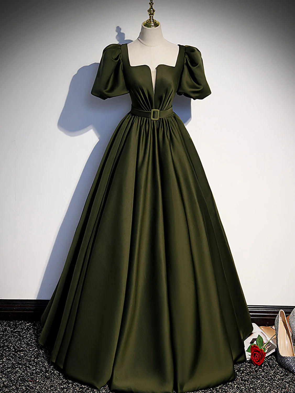 Front view of an elegant green satin A-line long ball gown.