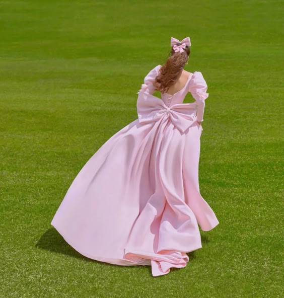 Close-up of pink satin fabric and puff sleeve detail on a formal dress.