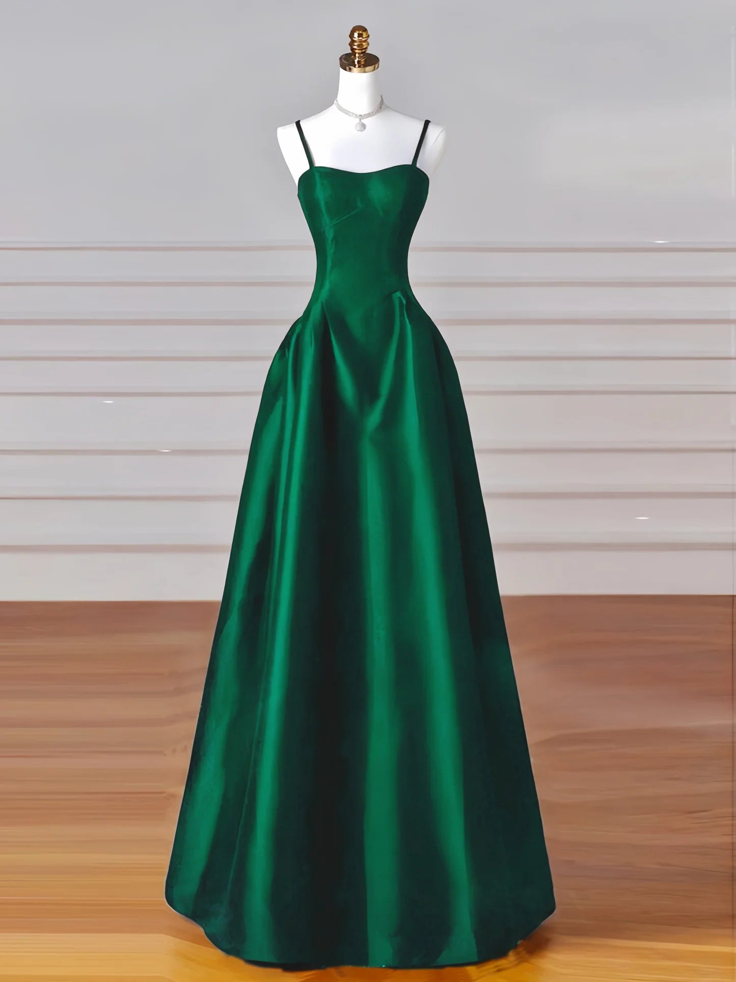 Full-length view of a woman wearing an elegant A-line satin green long prom dress.