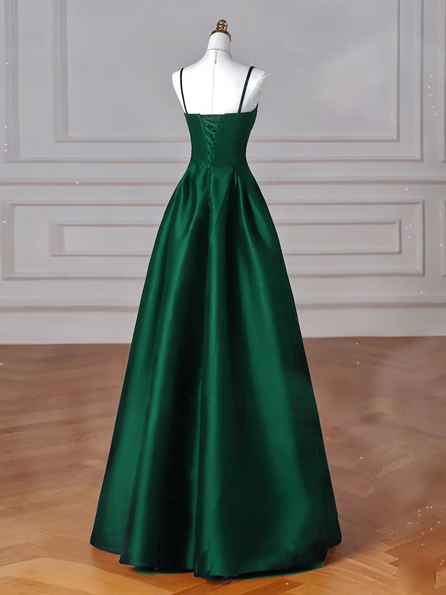 Side view of a woman wearing an A-line satin green long formal gown.