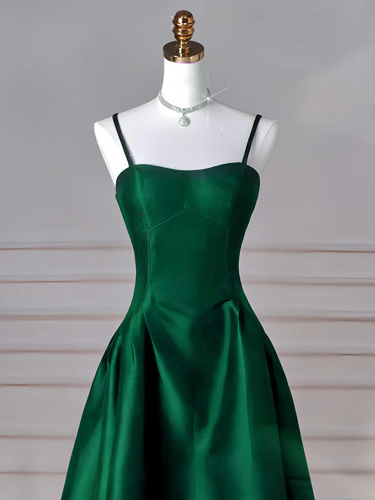 Close-up of the luxurious satin fabric and flowing skirt of the green formal dress.