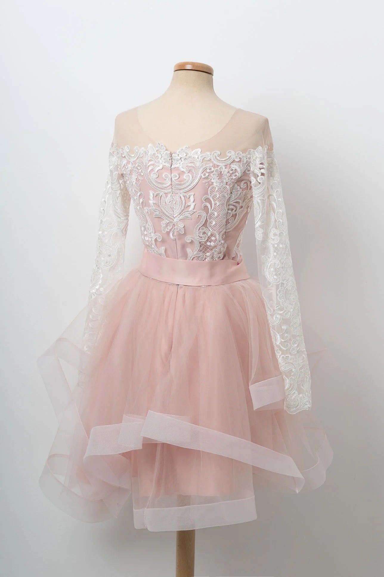 Back view of the pink short A-line dress, highlighting its intricate tulle and lace fabric.