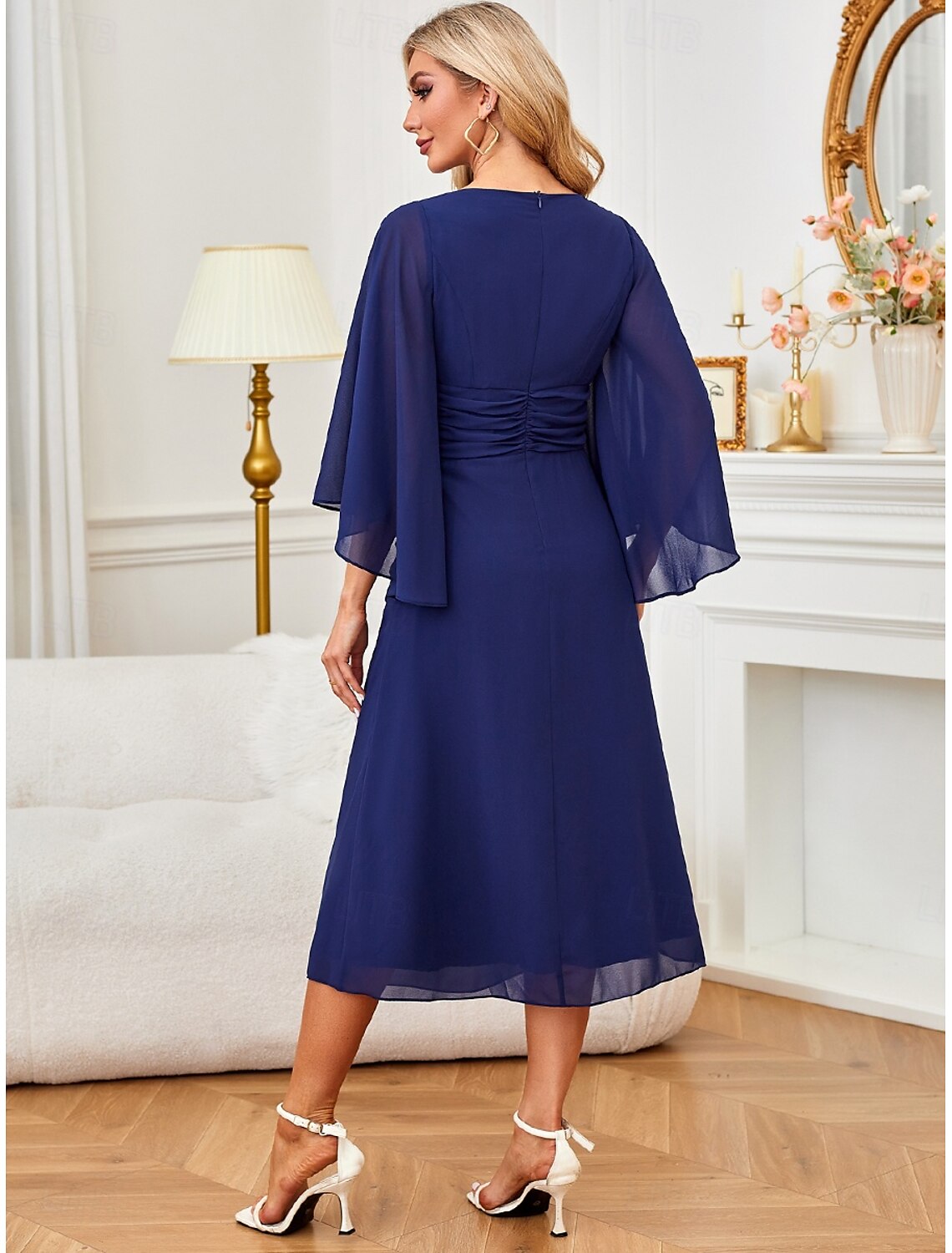 Woman posing in a dark blue A-line ruched ruffle half-sleeve midi dress, side view.