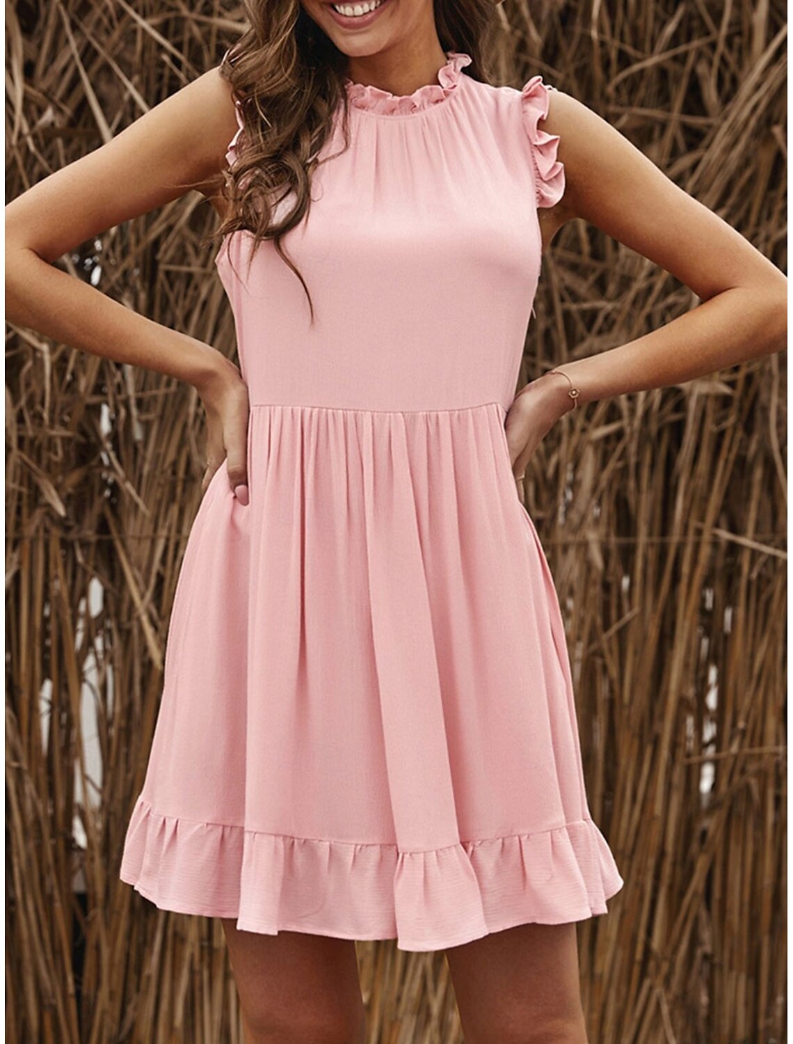Full-length view of a woman posing in a chic A-line ruffle mini dress.
