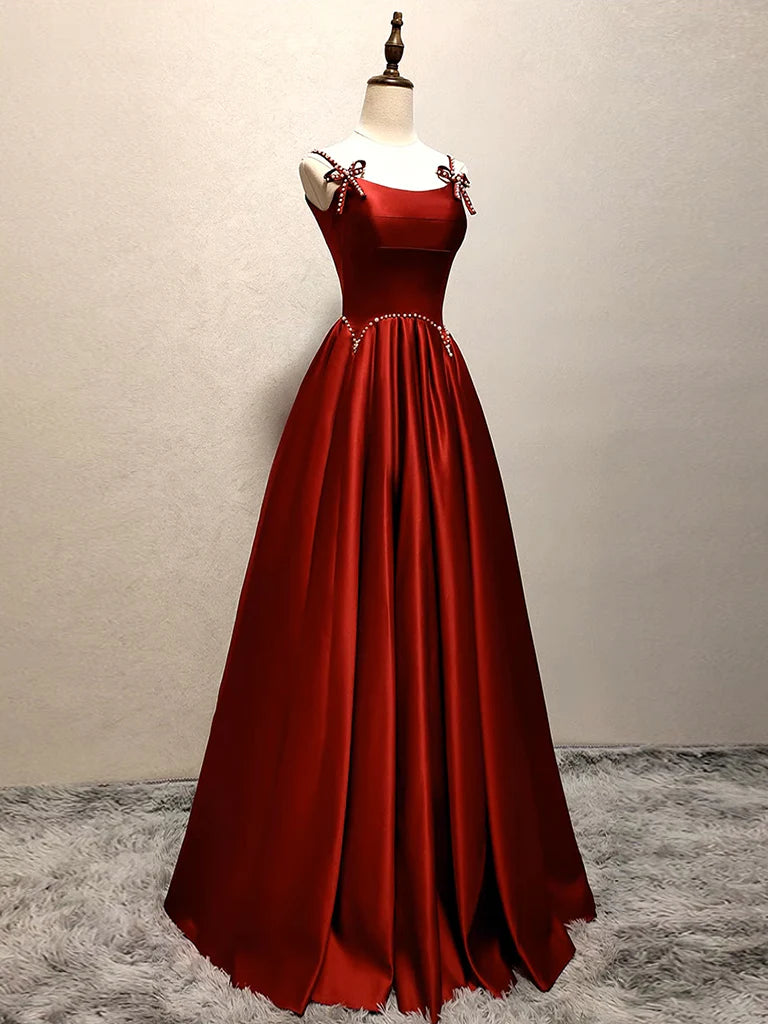 Model wearing an elegant A-line satin burgundy long prom dress.