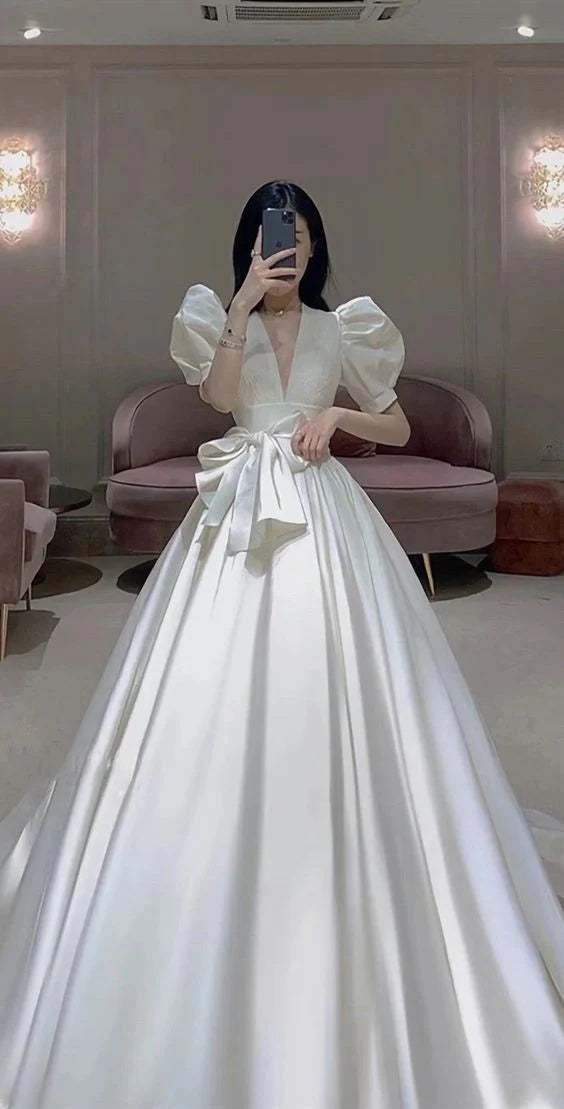 Elegant A-line satin wedding dress with V-neck and short puff sleeves.