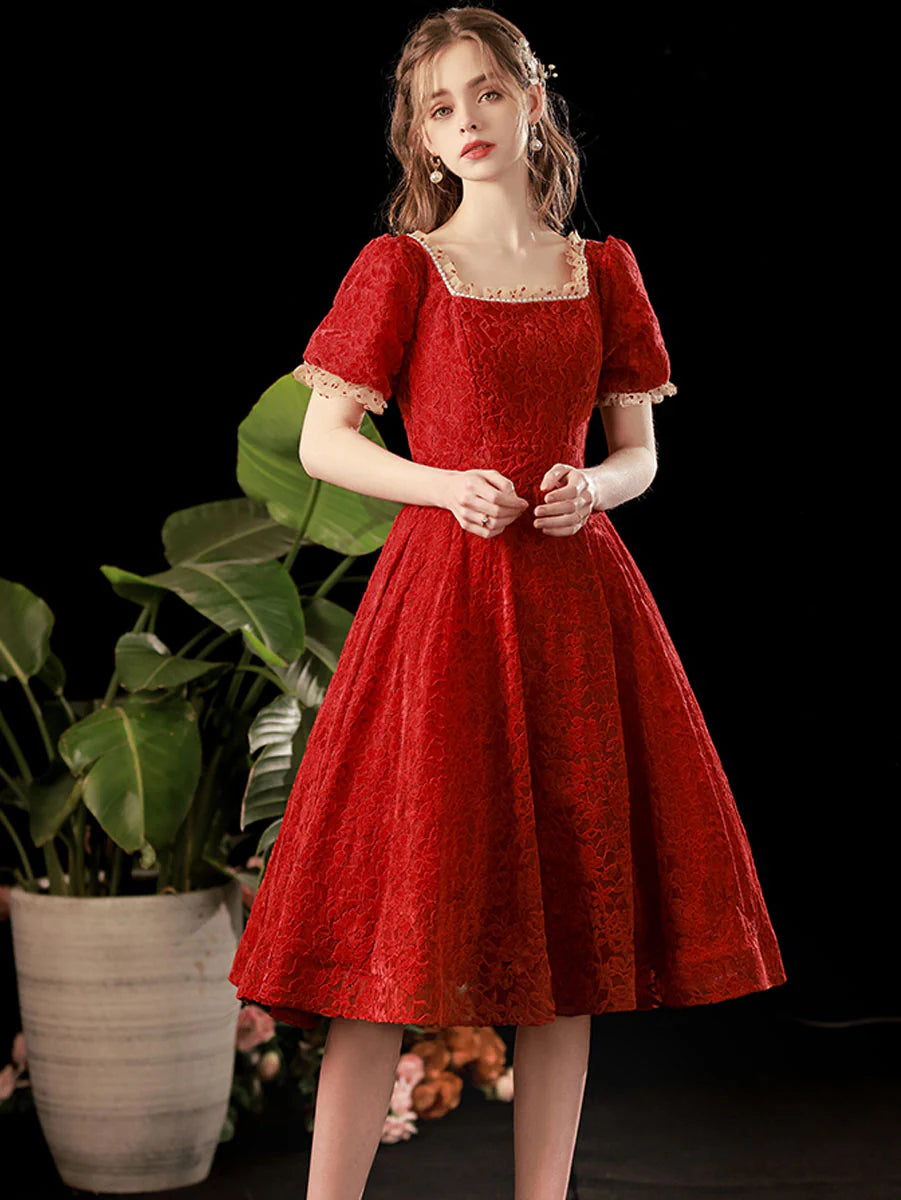 Model posing in an elegant burgundy short homecoming dress.