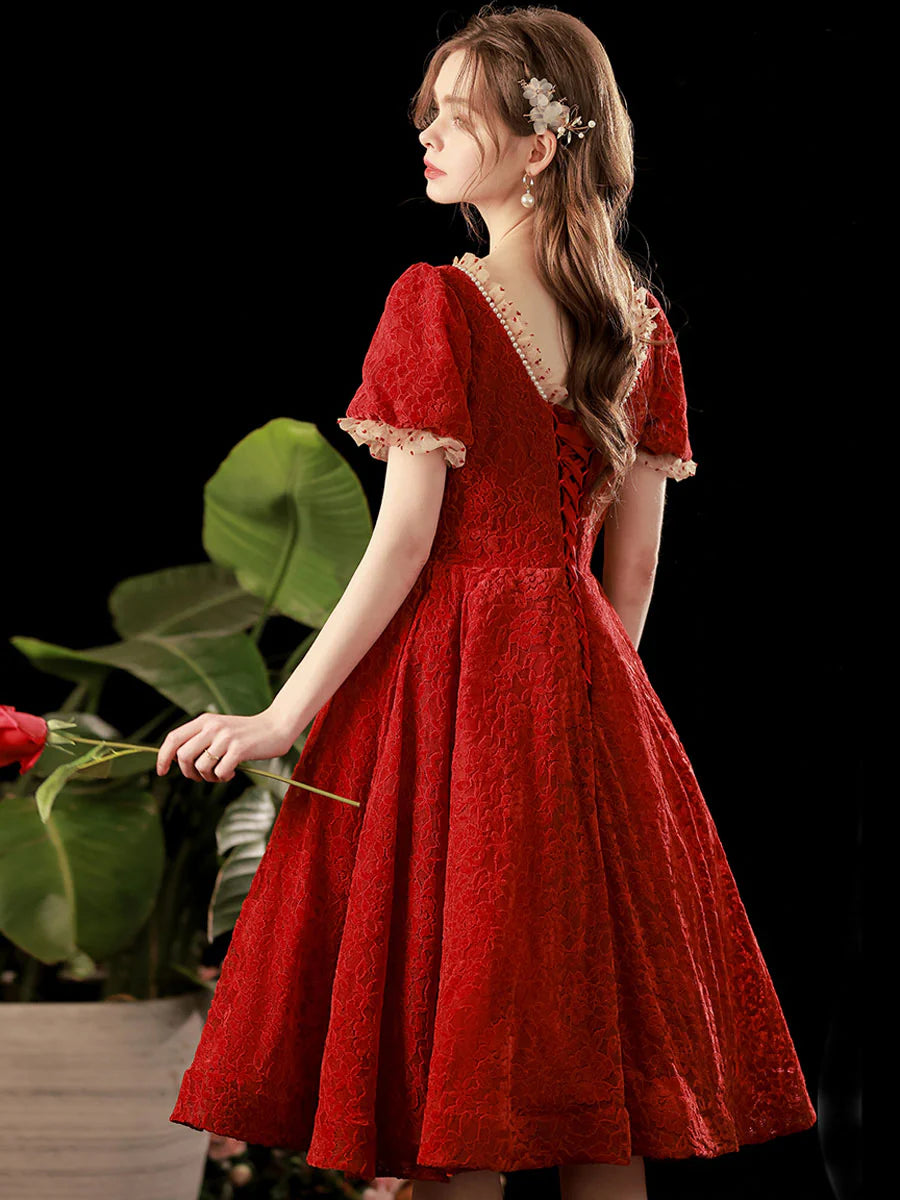 Close-up of the delicate lace detail on the burgundy dress.