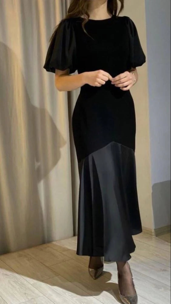 Woman wearing an elegant black velvet and satin short sleeve modest prom dress.