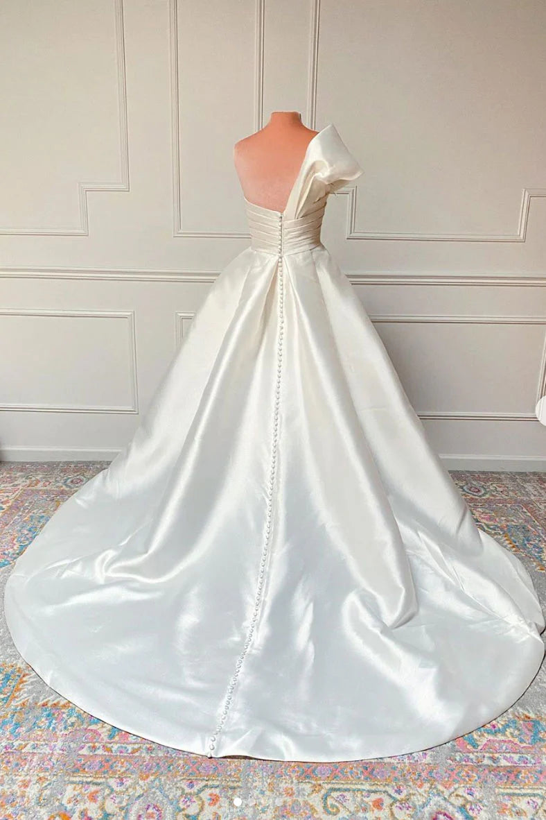 Woman posing in a white satin long wedding gown.