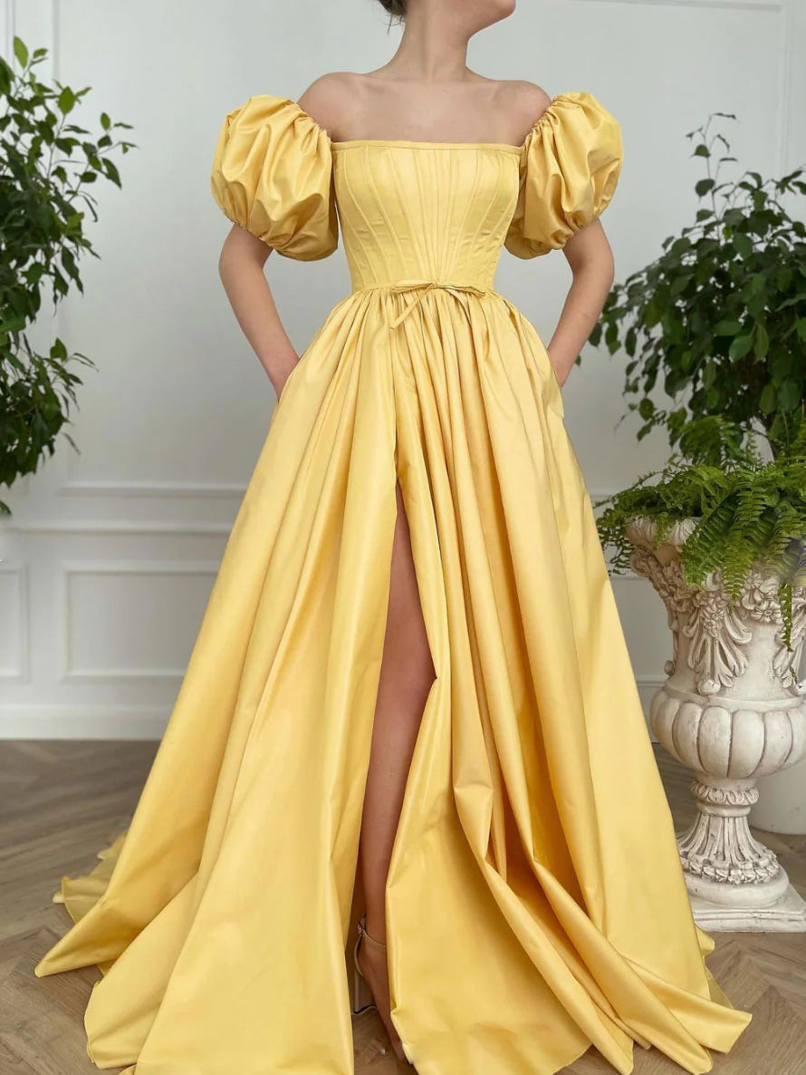 Woman wearing an elegant yellow satin long prom dress with a fitted waist.
