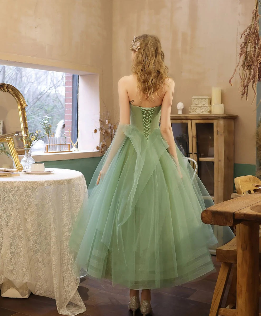 Side view of a green A-line tea-length formal dress, showcasing the tulle skirt.