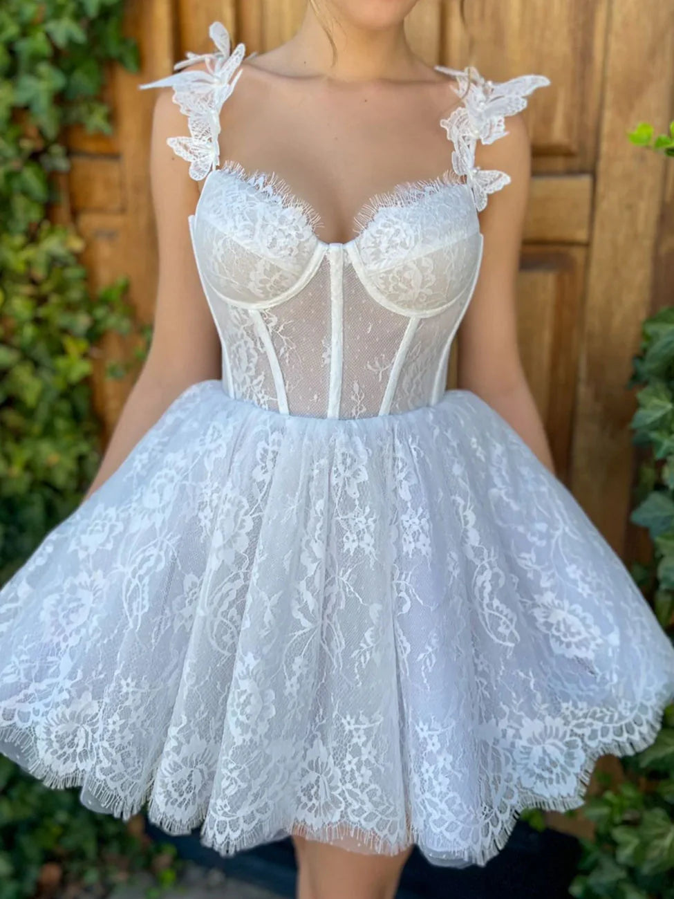 Model wearing an elegant white lace mini homecoming dress, back view.