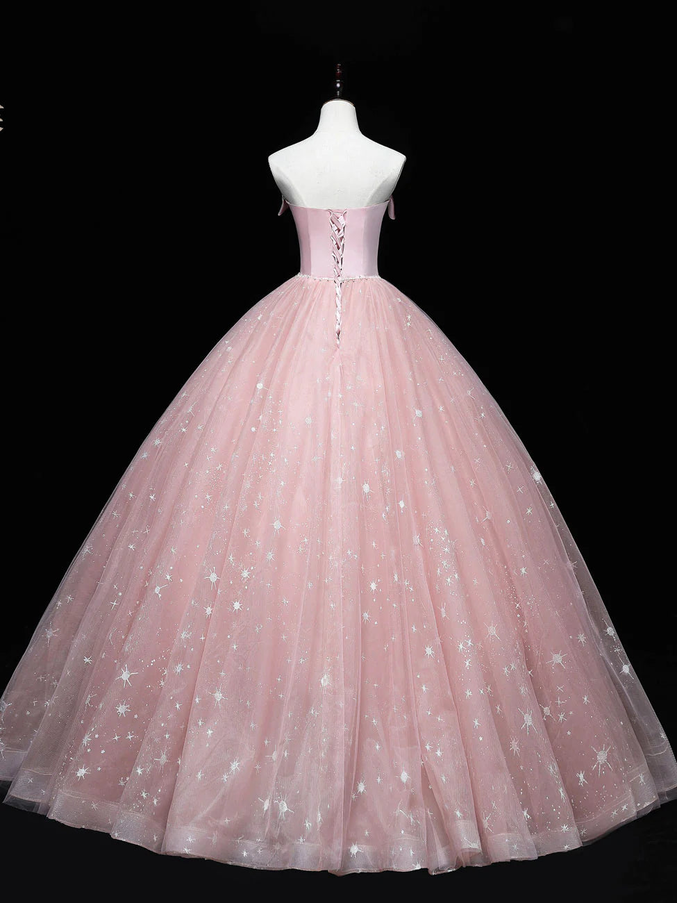 Back view of a model wearing a long pink tulle prom dress.