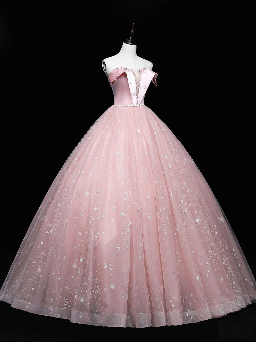 Side profile of a model in a graceful pink tulle ball gown.