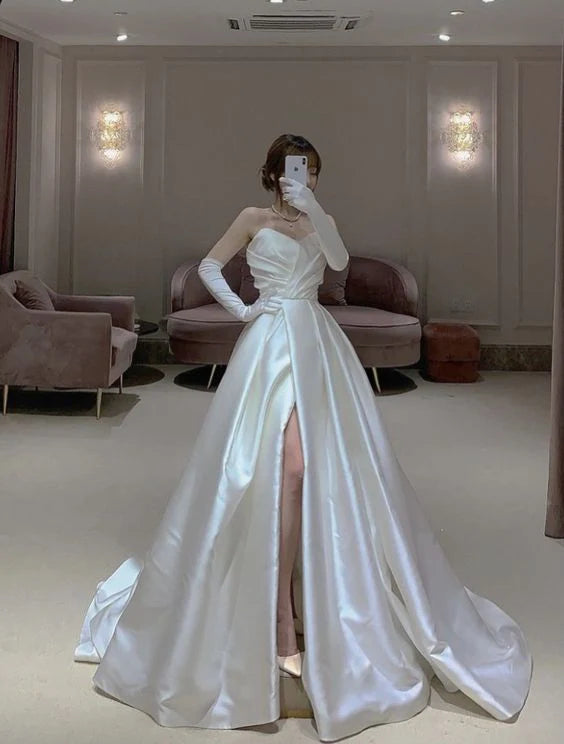 Elegant white sleeveless satin A-line wedding dress with delicate pleats and a floor-length skirt.