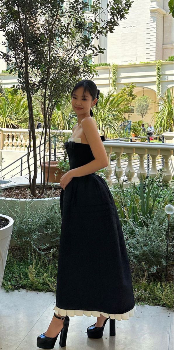 Side view of black A-line satin prom dress with fitted waist.