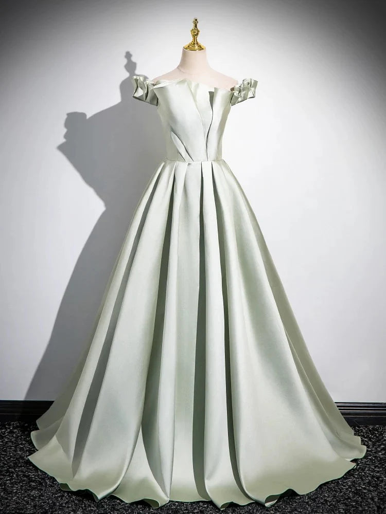 Woman wearing an elegant A-line satin green long prom dress.