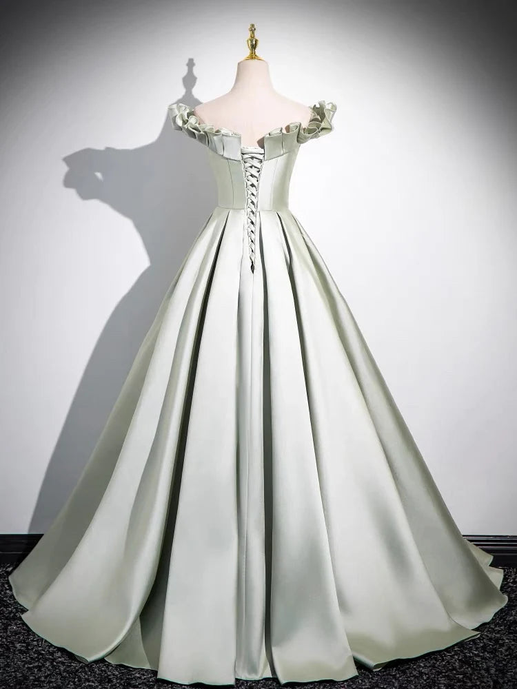 Back view of a woman in a flowing green satin formal dress.