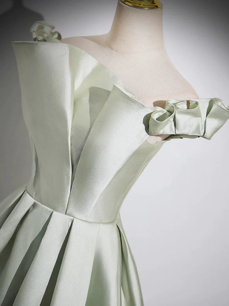 Side profile of a woman posing in a vibrant green evening gown.