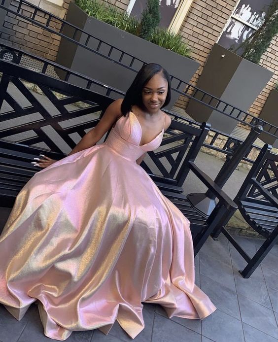 Woman wearing an elegant pink satin sleeveless A-line long evening dress.