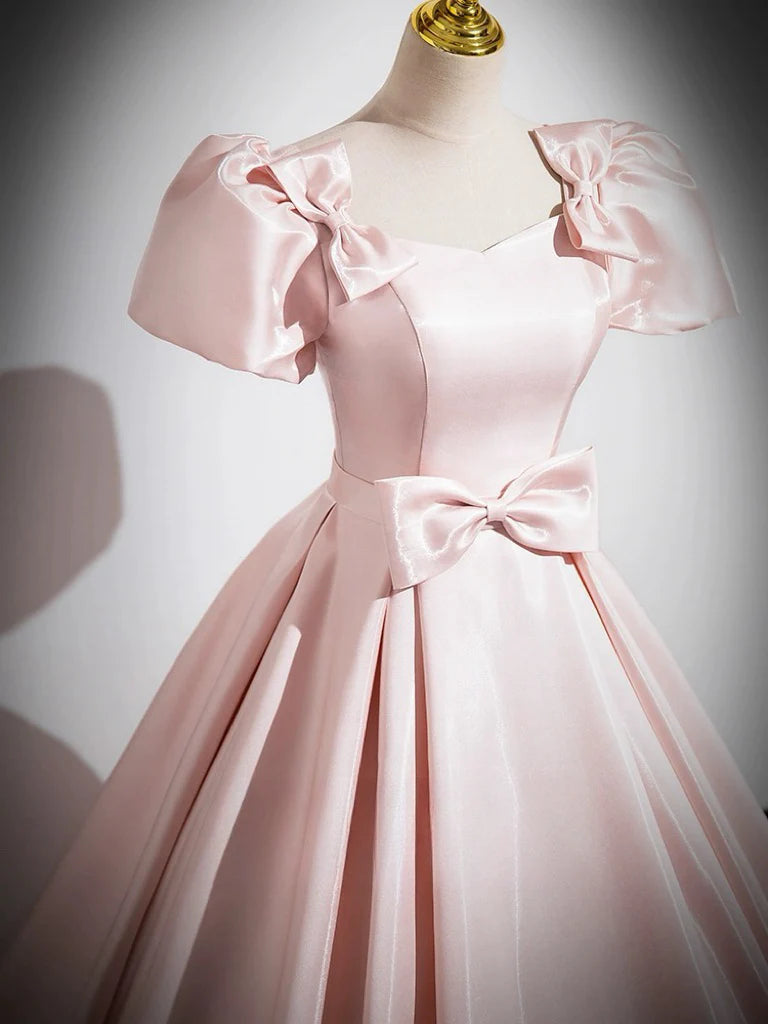 Side view of a woman wearing a pink satin formal gown.