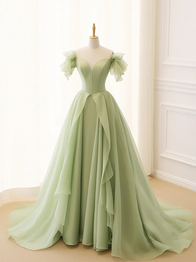 Woman wearing an elegant A-line green tulle long prom dress, front view.