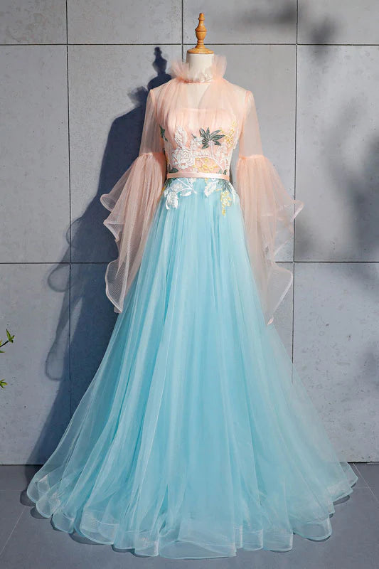 Woman wearing a blue tulle lace long prom dress with a flowing skirt.