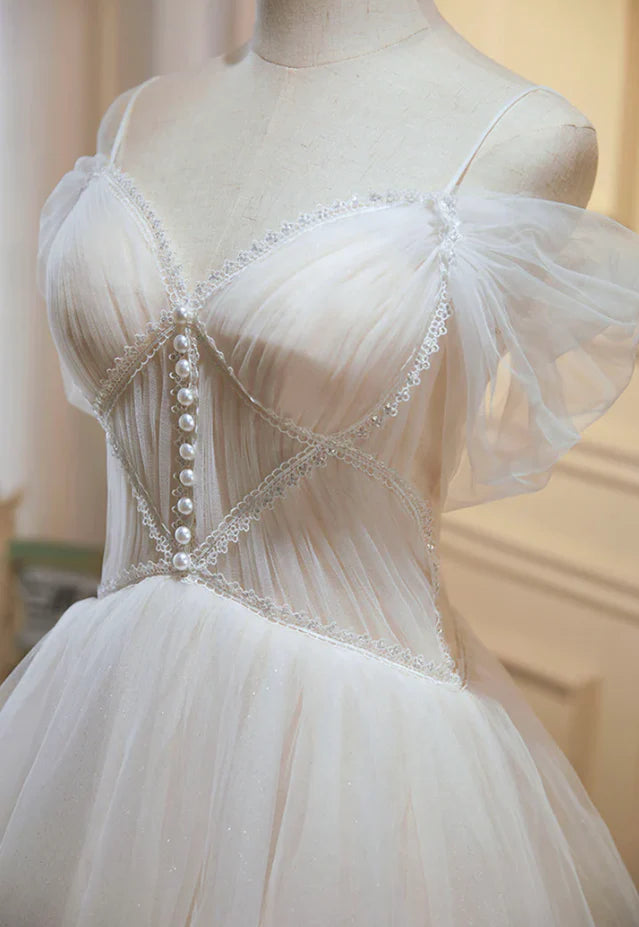 Close-up of the delicate lace and tulle fabric on a champagne dress.