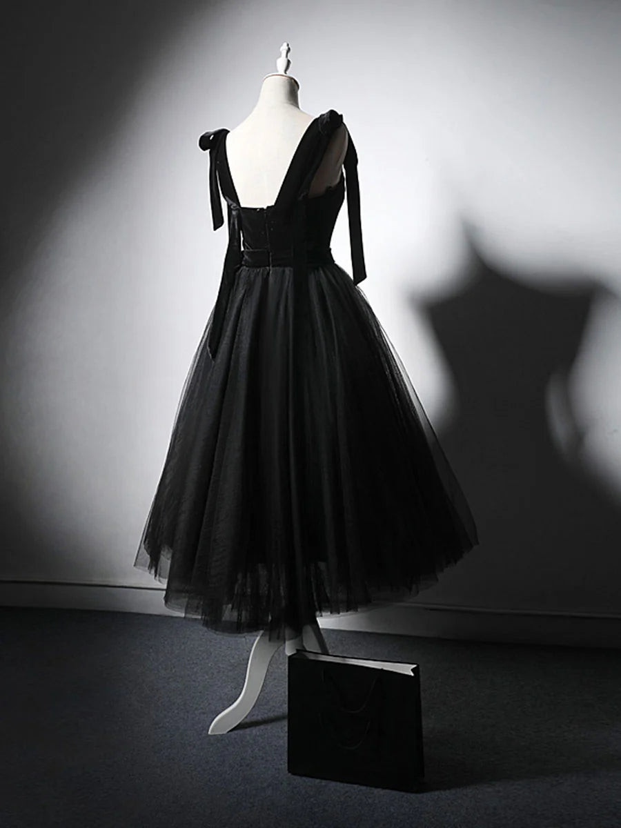 Back view of a woman wearing an elegant black tulle and lace short homecoming dress.