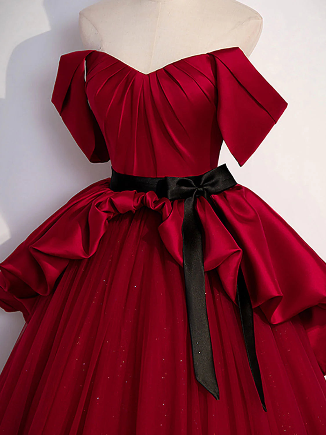 Model in elegant A-line burgundy satin long evening dress, side view.