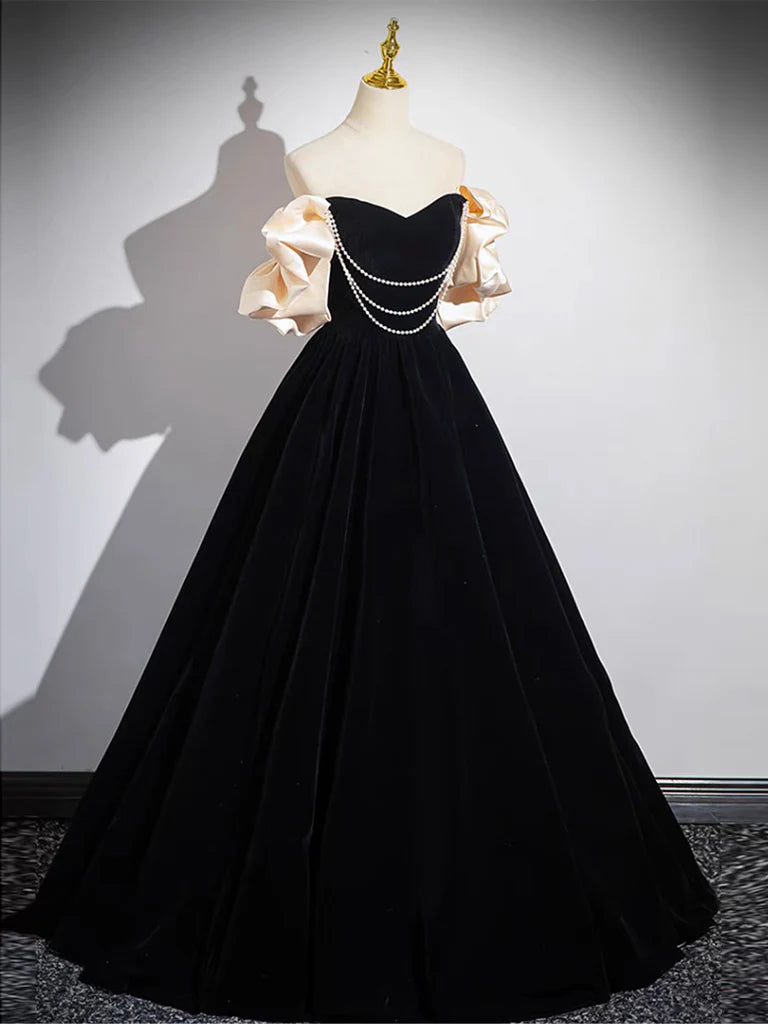 Model wearing a black velvet A-line long prom dress, front view.