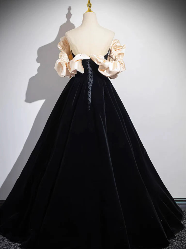 Side view of a model in a black velvet long evening dress.