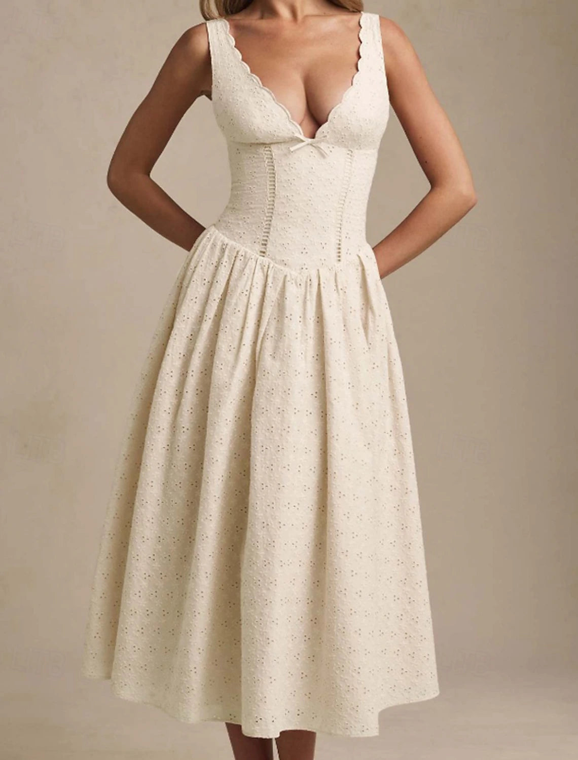 Woman wearing an elegant white sleeveless A-line midi dress.
