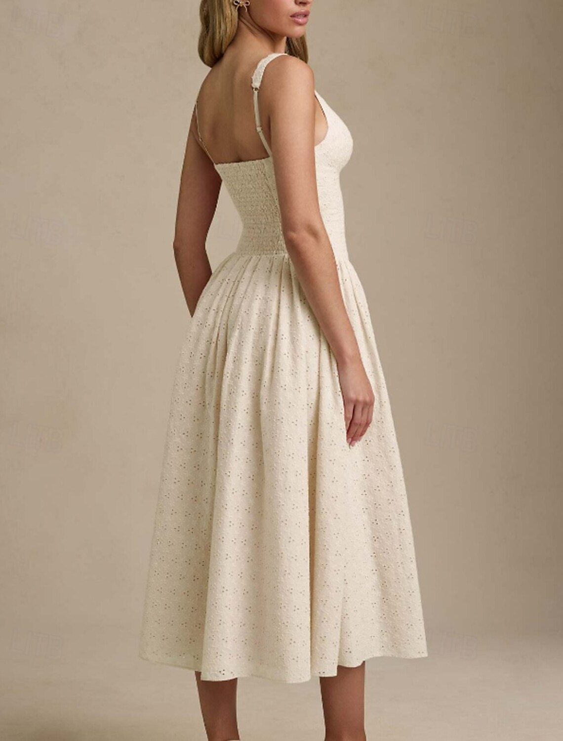 Woman posing gracefully in a white midi dress for a party or graduation.