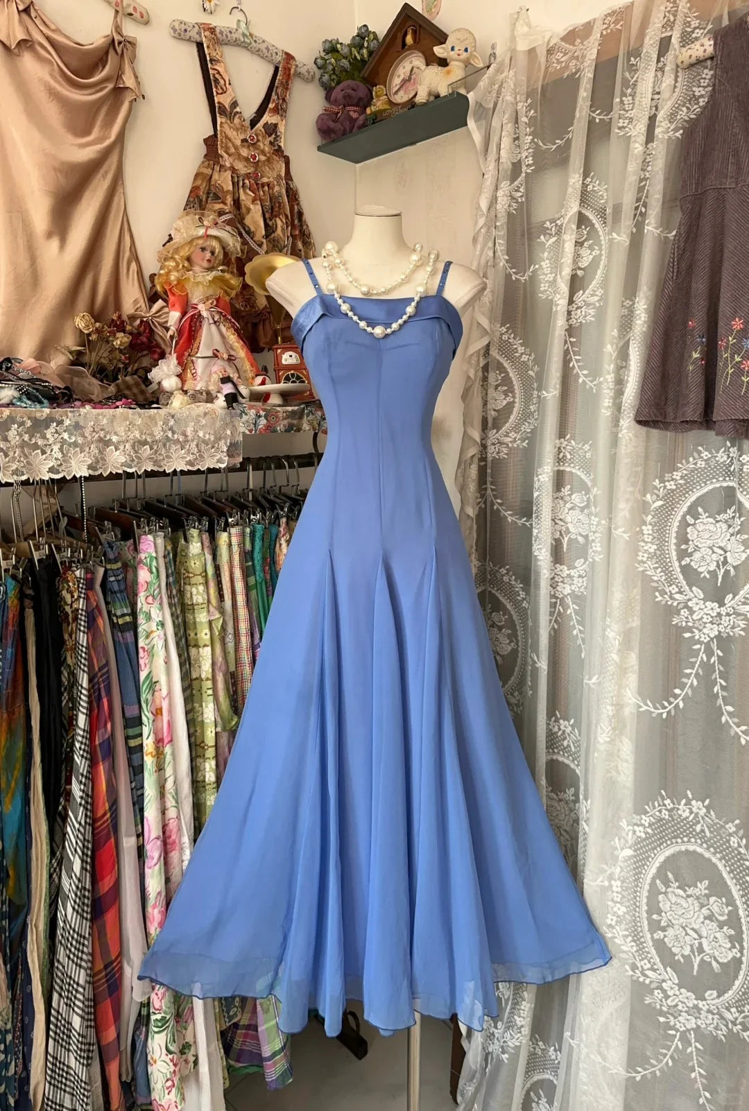Model wearing an elegant blue spaghetti strap ankle-length prom dress, front view.