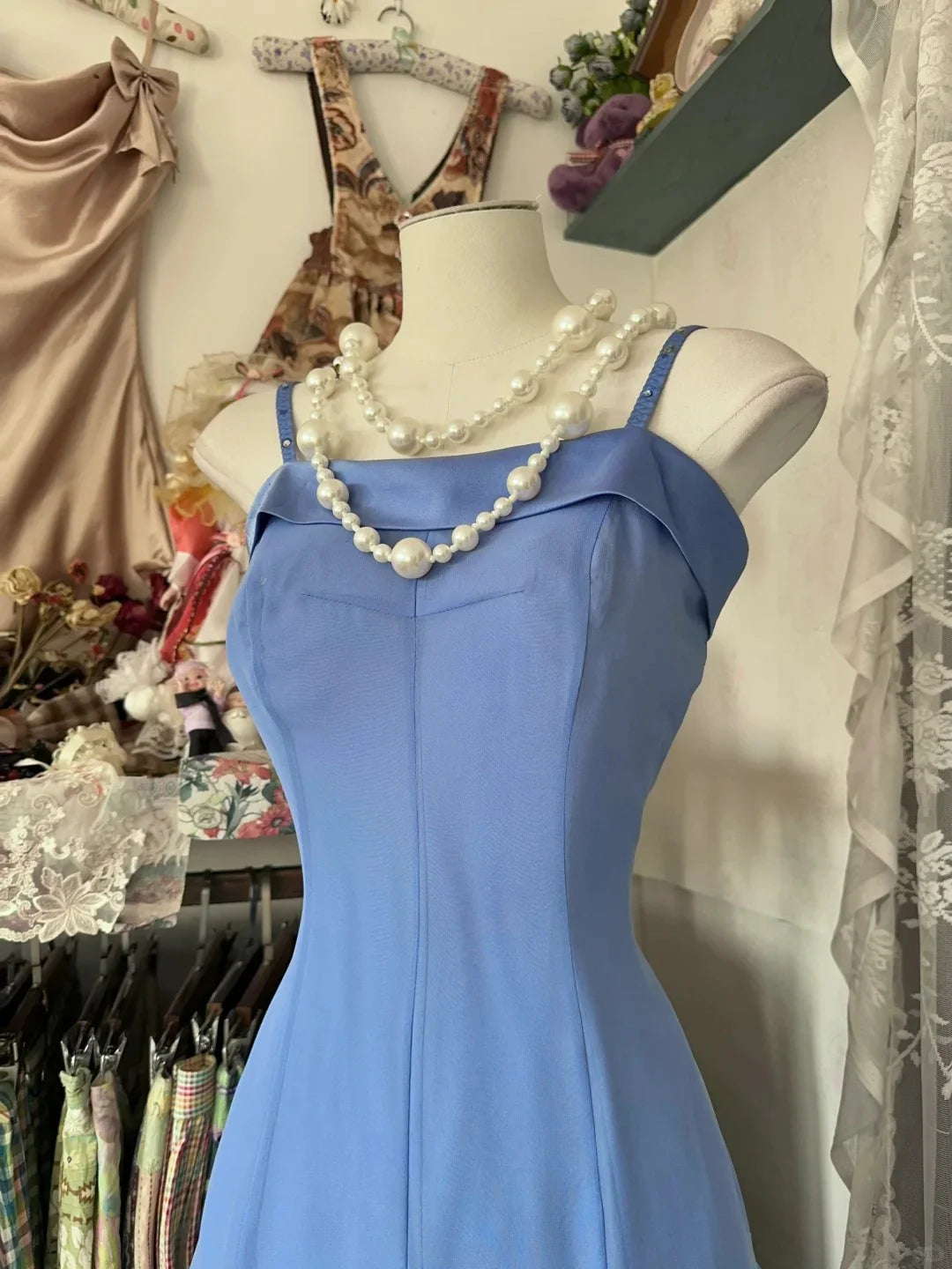 Model in a blue spaghetti strap ankle-length dress, side view, showcasing the flowing A-line skirt.
